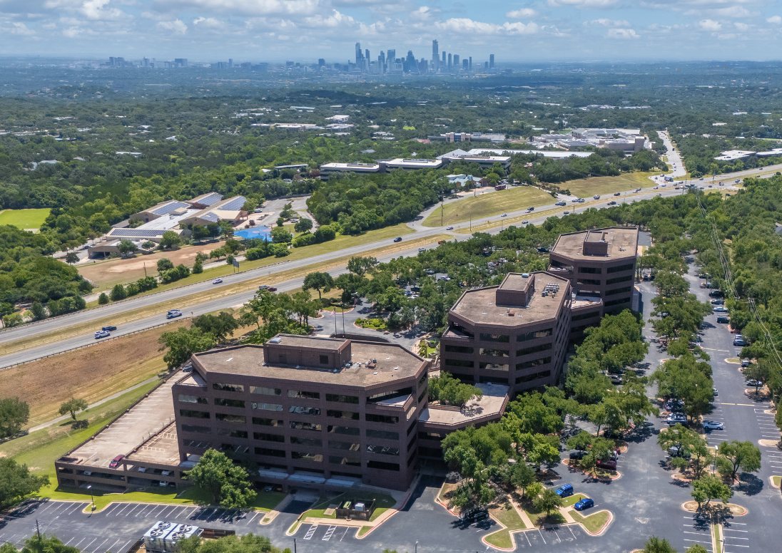 Aerial view of Cielo Center's three office buildings with the downtown Austin skyline in the distance
